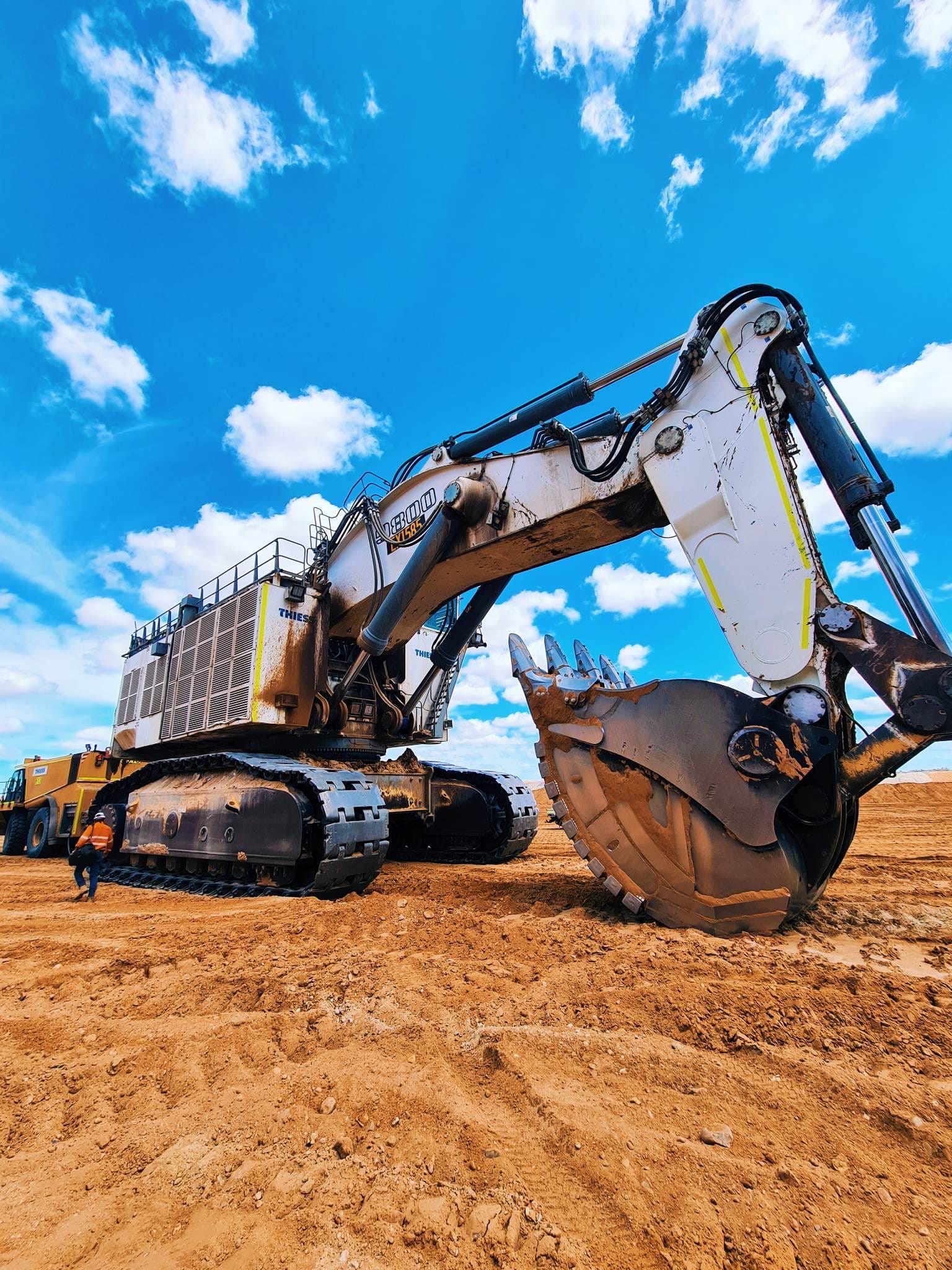 Large hydraulic mining excavator with bucket lowered on a prepared pad